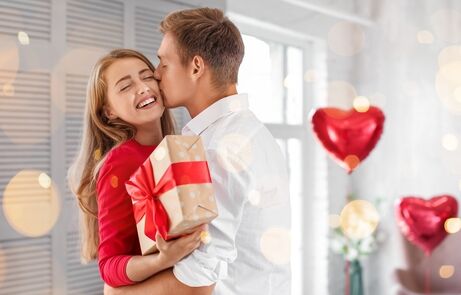 Young,Couple,With,Gift,For,Valentine's,Day,Hugging,At,Home